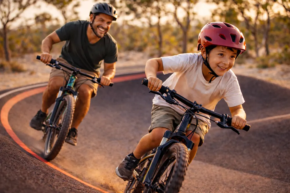 Pai e filho pedalando na pista de bike / pump track